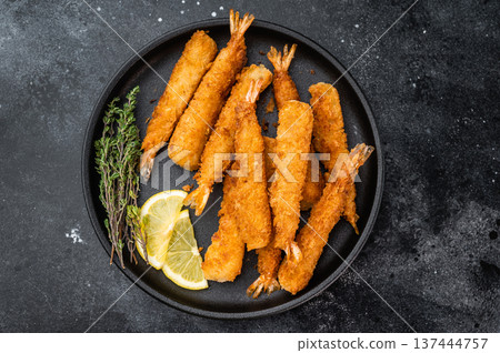 Panko fried prawns or ebi fry arranged on plate with sauce bowl and citrus wedges, crunchy deep fried seafood snack shot from above with copy space. 137444757