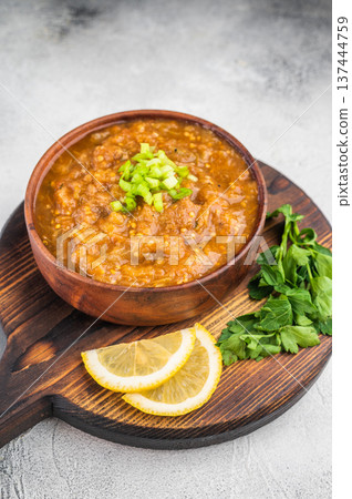 Traditional baigan bharta roasted eggplant aubergine mash served in rustic bowl on wooden board with lemon slices on light textured background top view Traditional baigan bharta roasted eggplant aubergine mash served in rustic bowl on wooden board with lemon slices on light textured background top view 137444759
