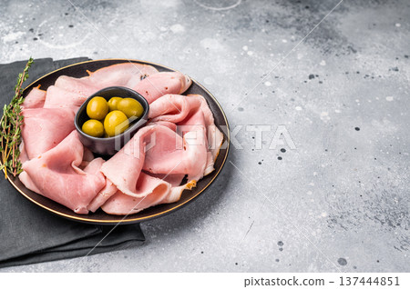 Meat appetizer with Sliced Prosciutto Cotto ham and green olives. grey background. top view Meat appetizer with Sliced Prosciutto Cotto ham and green olives. grey background. top view 137444851