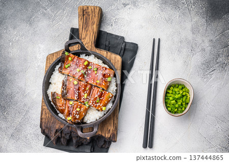 Japanese Cuisine Unadon, grilled unagi eel with rice in a skillet. white background. top view Japanese Cuisine Unadon, grilled unagi eel with rice in a skillet. white background. top view 137444865