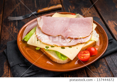 Prosciutto Cotto Ham and cheese sandwich, toast with sliced meat, cheese and salad. wooden background. top view Prosciutto Cotto Ham and cheese sandwich, toast with sliced meat, cheese and salad. wooden background. top view 137444872