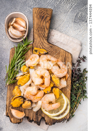 Fresh Seafood cocktail, raw Mix with Mussels, Clams, Prawns, Shrimps and squid on wooden board. white background. top view Fresh Seafood cocktail, raw Mix with Mussels, Clams, Prawns, Shrimps and squid on wooden board. white background. top view 137444894