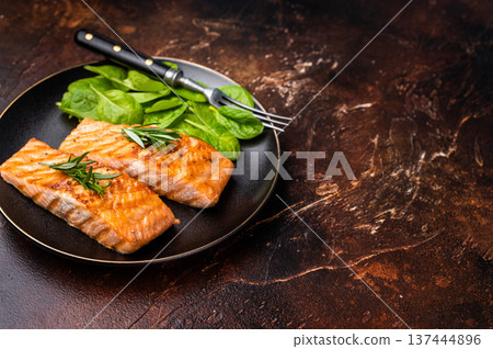 Grilled salmon fillet with spinach, fish steak in a plate. brown background. top view 137444896