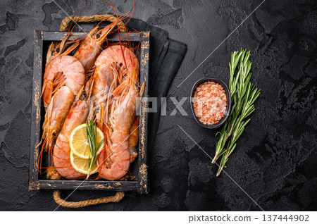 Uncooked raw Red shrimps, Prawns Langostino Austral in wooden tray. black background. top view Uncooked raw Red shrimps, Prawns Langostino Austral in wooden tray. black background. top view 137444902