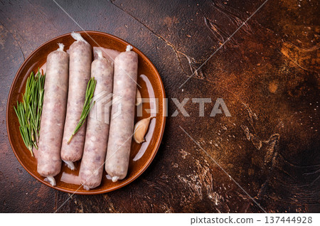 Raw Sausages with forcemeat mincemeat with herbs in plate. brown background. top view Raw Sausages with forcemeat mincemeat with herbs in plate. brown background. top view 137444928