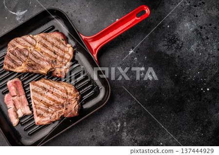 Fried on grill skillet pork tender steak, neck meat. black background. top view Fried on grill skillet pork tender steak, neck meat. black background. top view 137444929