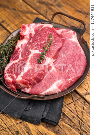 Uncooked pork tender steak, raw sliced neck meat with thyme. wooden background. top view 137444931
