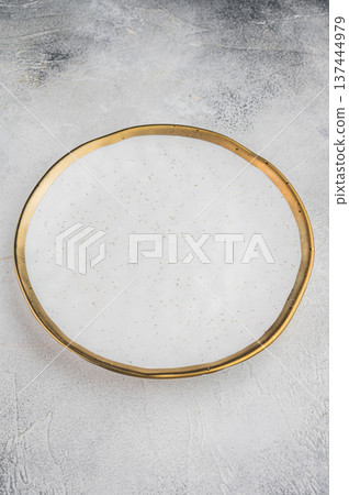 Round porcelain plate top view on neutral backdrop, elegant minimal table setting concept ideal for menu presentation or branding 137444979