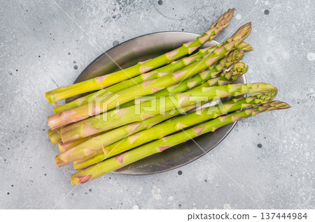 Green asparagus stalks on gray surface with copy space, fresh seasonal vegetable ingredient in minimal studio food photography style Green asparagus stalks on gray surface with copy space, fresh seasonal vegetable ingredient in minimal studio food photography style 137444984