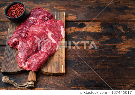 Uncooked raw hanger onglet beef cut on vintage wooden board top view rustic food styling with spices fork and natural butcher preparation mood Uncooked raw hanger onglet beef cut on vintage wooden board top view rustic food styling with spices fork and natural butcher preparation mood 137445017