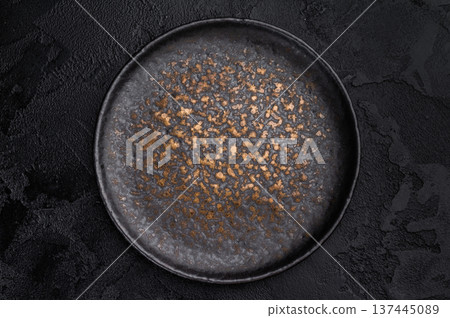 Empty black plate top view on dark textured background. Minimal luxury tableware mockup with copy space Empty black plate top view on dark textured background. Minimal luxury tableware mockup with copy space 137445089