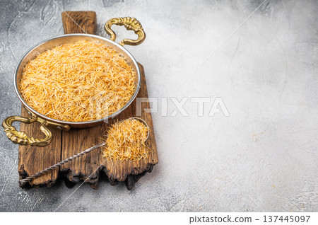 Raw kataifi pastry strands for kunafa and Middle Eastern desserts. Thin shredded phyllo texture on concrete background 137445097