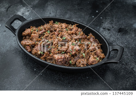 Slow cooked kawurma with shredded and diced beef chunks highlighting protein breakdown, caramelized surfaces and rustic ironpan presentation. Slow cooked kawurma with shredded and diced beef chunks highlighting protein breakdown, caramelized surfaces and rustic ironpan presentation. 137445109