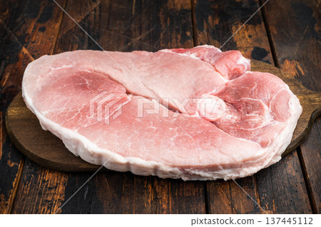 Fresh raw pork shoulder with bone on cutting board wooden background uncooked meat garnished with rosemary for butcher cooking and bbq 137445112