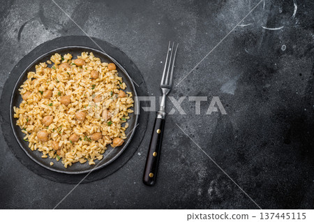 Traditional Turkish bulgur pilav with chickpeas vegan plant based dish on dark textured background overhead Traditional Turkish bulgur pilav with chickpeas vegan plant based dish on dark textured background overhead 137445115