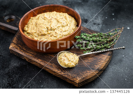 German Bavarian sweet mustard condiment closeup showing thick grainy texture in wooden bowl on black background German Bavarian sweet mustard condiment closeup showing thick grainy texture in wooden bowl on black background 137445126
