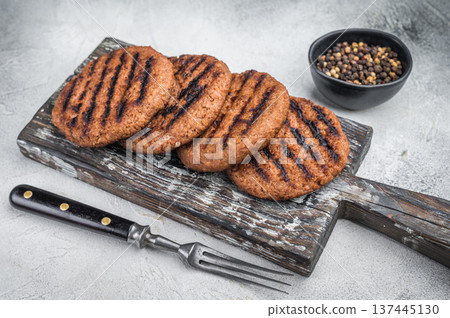 Grilled plant based burger patties vegan meat alternative on wooden board with fork light background top view copy space 137445130