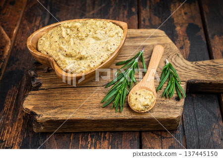 Bavarian sweet mustard with mild grainy texture in wooden bowl with spoon and rosemary flat lay on rustic wood background 137445150