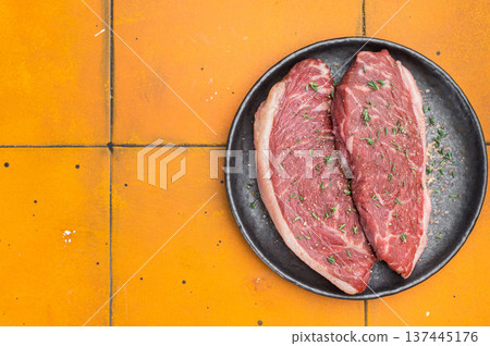 Raw beef culotte steaks also called picanha or rump cap on black ceramic plate, bright yellow stone background Raw beef culotte steaks also called picanha or rump cap on black ceramic plate, bright yellow stone background 137445176