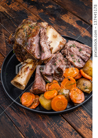 Braised Slow cooked beef osso buco with juicy meat texture marrow bone and roasted vegetables top view Braised Slow cooked beef osso buco with juicy meat texture marrow bone and roasted vegetables top view 137445178