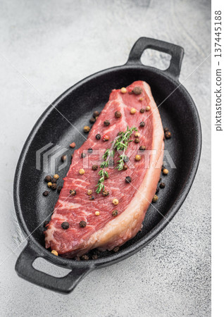 Raw picanha beef steak also known as top sirloin cap and rump cap with thyme and pepper in cast iron pan, stone background Raw picanha beef steak also known as top sirloin cap and rump cap with thyme and pepper in cast iron pan, stone background 137445188