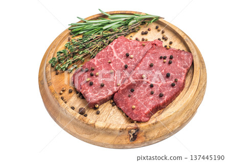 Fresh raw beef steak flatiron cut with herbs and spices on rustic wooden board overhead view isolated background Fresh raw beef steak flatiron cut with herbs and spices on rustic wooden board overhead view isolated background 137445190