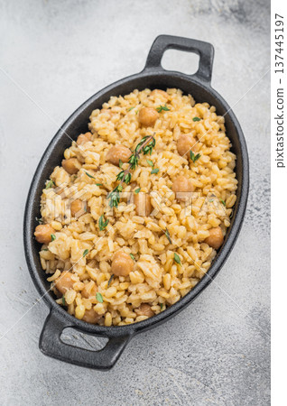 Traditional Turkish bulgur pilav with chickpeas vegan plant based dish in black cast iron skillet overhead Traditional Turkish bulgur pilav with chickpeas vegan plant based dish in black cast iron skillet overhead 137445197