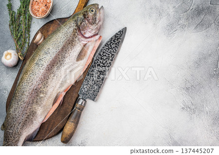 Whole raw rainbow trout on wooden board with knife salt garlic and herbs flat lay on stone background with copy space Whole raw rainbow trout on wooden board with knife salt garlic and herbs flat lay on stone background with copy space 137445207