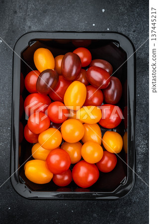 Fresh organic cherry tomatoes arranged in a retail style container clean minimal top view great for healthy cooking and salad concepts. Fresh organic cherry tomatoes arranged in a retail style container clean minimal top view great for healthy cooking and salad concepts. 137445217