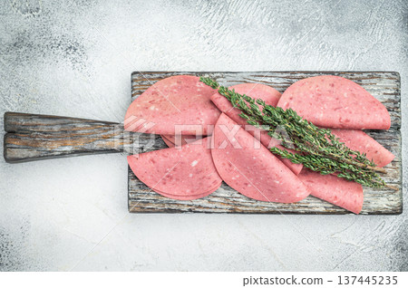 Soft textured beef salam slices on weathered wooden board with thyme sprigs on bright studio background ideal for gourmet food prep and stock imagery Soft textured beef salam slices on weathered wooden board with thyme sprigs on bright studio background ideal for gourmet food prep and stock imagery 137445235