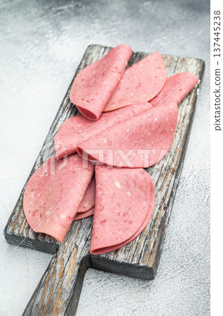 Soft textured beef salam slices on weathered wooden board with thyme sprigs on bright studio background ideal for gourmet food prep and stock imagery Soft textured beef salam slices on weathered wooden board with thyme sprigs on bright studio background ideal for gourmet food prep and stock imagery 137445238