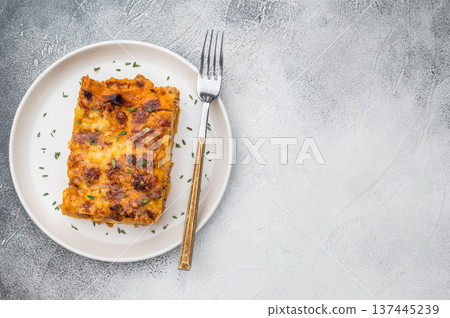 Homemade beef lasagna slice with rich meat sauce pasta sheets and cheesy crust served on white plate 137445239