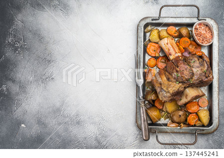 Slow roasted beef shank osso buco with marrow bone potatoes carrots and herbs in metal tray copy space Slow roasted beef shank osso buco with marrow bone potatoes carrots and herbs in metal tray copy space 137445241