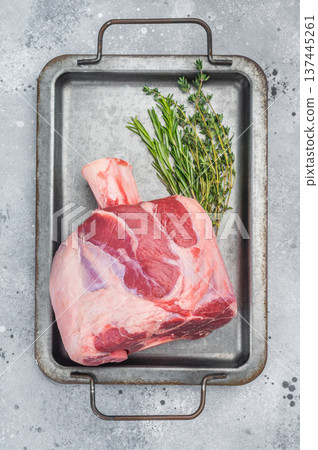 Raw veal shank calf meat with bone rosemary thyme and salt on metal tray top view for ossobuco Raw veal shank calf meat with bone rosemary thyme and salt on metal tray top view for ossobuco 137445261