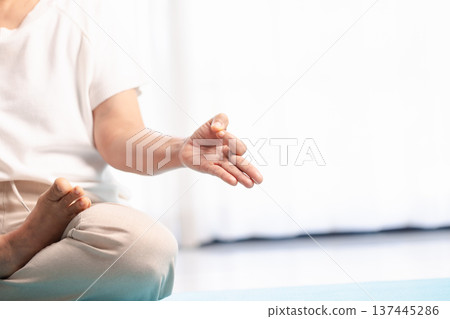Close-up of hands in yoga meditation mudra during mindfulness practice, soft bright background with copy space. Calm wellness concept for relaxation, breathing, zen and mental health. Close-up of hands in yoga meditation mudra during mindfulness practice, soft bright background with copy space. Calm wellness concept for relaxation, breathing, zen and mental health. 137445286