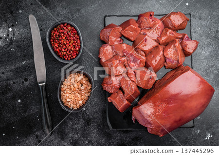 Fresh raw beef liver prepared for cooking with knife and board. Whole and diced organ meat veal calf. Fresh raw beef liver prepared for cooking with knife and board. Whole and diced organ meat veal calf. 137445296