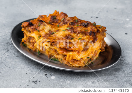 Classic Italian lasagne al forno with beef meat sauce and melted cheese on plate over rustic wooden board Classic Italian lasagne al forno with beef meat sauce and melted cheese on plate over rustic wooden board 137445370