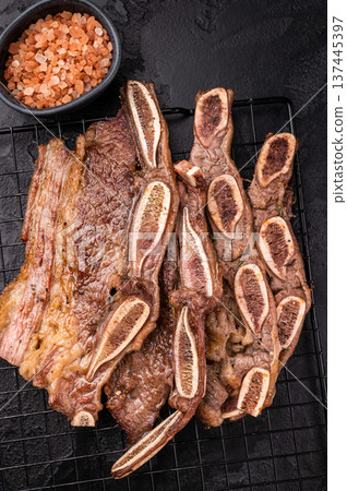 Top view of Korean BBQ Kalbi on a cooling rack. Dark food photography, ready to serve, perfect for restaurant menus. Top view of Korean BBQ Kalbi on a cooling rack. Dark food photography, ready to serve, perfect for restaurant menus. 137445397