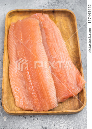 Fresh raw salmon fillet Salmo salar on wooden board. Clean flat lay food photography with salt on light gray background.. 137445462