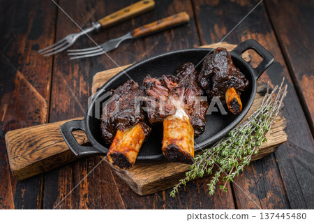Cooked beef plate ribs slow cooked until tender with bone and herbs. BBQ style beef plate ribs on dark wooden background with copy space. 137445480