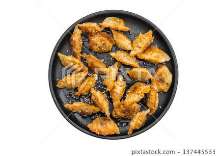 Crispy fried gyoza dumplings with sesame on a black plate over light background. Asian potstickers appetizer perfect for menu or food ads. 137445533