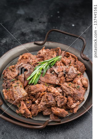 Slowcooked wild venison moose meat, tender and juicy, served with rosemary on rustic metal plate against dark textured stone surface Slowcooked wild venison moose meat, tender and juicy, served with rosemary on rustic metal plate against dark textured stone surface 137445561