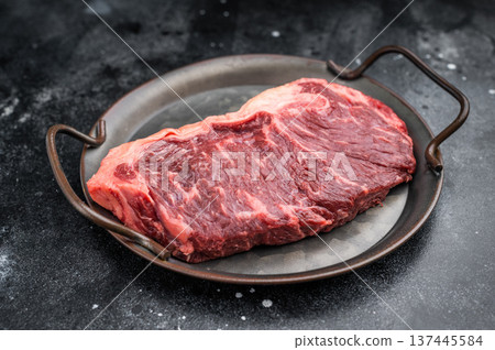 Beef raw sirloin cut or strip loin with herbs and seasoning on iron pan against rough dark background ideal for recipe blogs grilling menus and cuisine visuals Beef raw sirloin cut or strip loin with herbs and seasoning on iron pan against rough dark background ideal for recipe blogs grilling menus and cuisine visuals 137445584