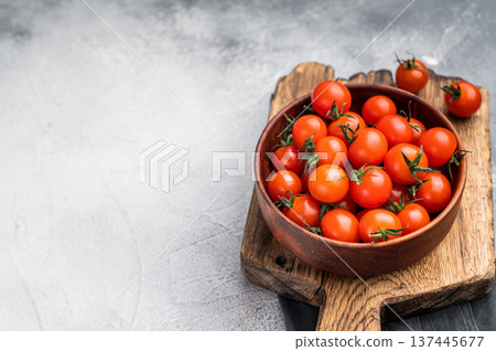 Plump cherry tomatoes, glistening under natural light, highlighting their freshness. Perfect for adding a burst of flavor to any recipe. grey background. top view Plump cherry tomatoes, glistening under natural light, highlighting their freshness. Perfect for adding a burst of flavor to any recipe. grey background. top view 137445677