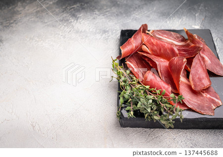 Sliced Speck bacon, Italian cured meat. grey background. top view 137445688