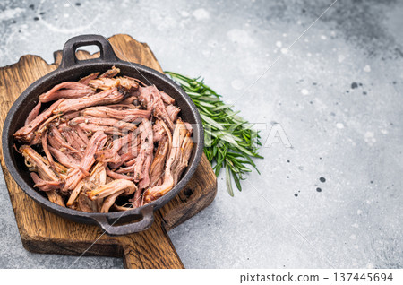 Savory pulled beef brisket served in a skillet, dipping creating an appealing and mouthwatering culinary scene. grey background. top view 137445694