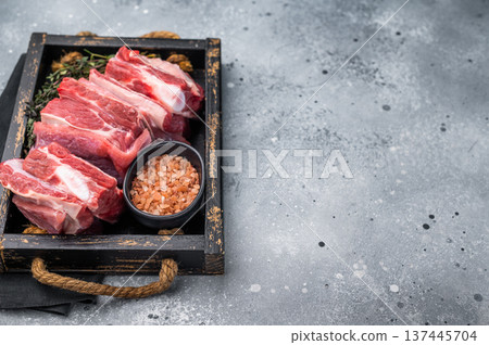 Fresh Raw lamb rib cuts, mutton meat with rib bone in wooden board. grey background. top view Fresh Raw lamb rib cuts, mutton meat with rib bone in wooden board. grey background. top view 137445704