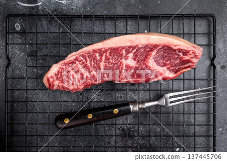 Raw beef picanha steak, featuring a thick layer of fat that adds flavor during cooking. black background. top view Raw beef picanha steak, featuring a thick layer of fat that adds flavor during cooking. black background. top view 137445706