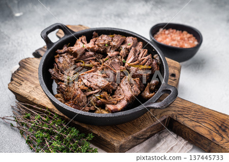 Slow cooked Shredded beef ragu in a skillet. grey background. top view Slow cooked Shredded beef ragu in a skillet. grey background. top view 137445733