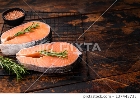 Vibrant raw salmon steak, showcasing its rich color and texture, ideal for sushi or sashimi enthusiasts seeking quality ingredients. wooden background. top view Vibrant raw salmon steak, showcasing its rich color and texture, ideal for sushi or sashimi enthusiasts seeking quality ingredients. wooden background. top view 137445735